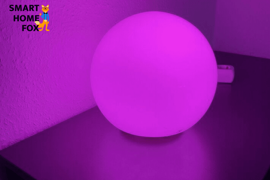 IKEA Tradfri Lampe steht auf dem Tisch und leuchtet lila